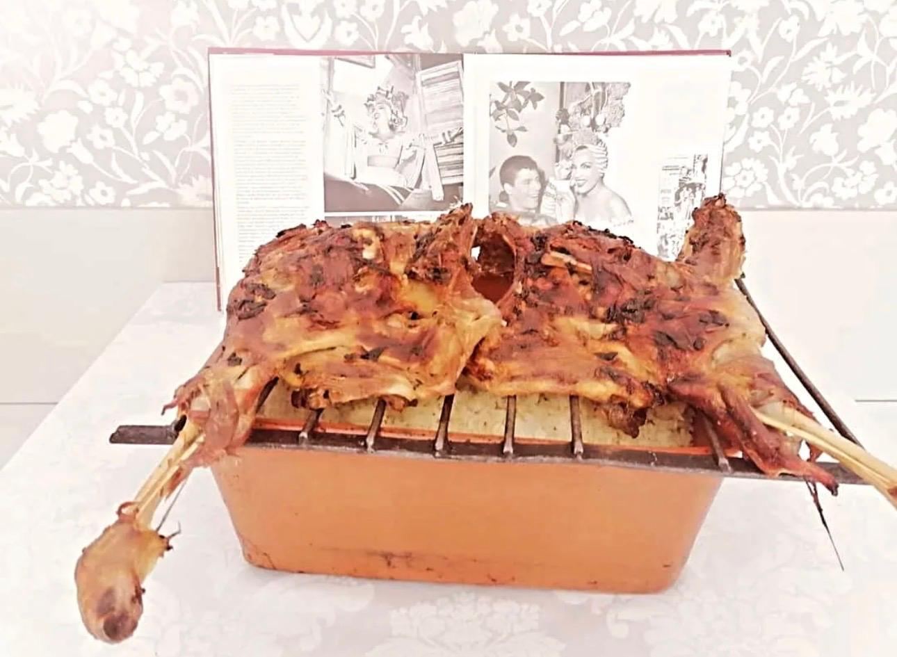 Anho assado no forno sobre o alguidar de arroz